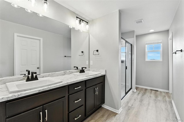 6513 Dry Fork Cir, Frederick, CO 80516 - bathroom with double vanity, a stall shower, and wood finished floors