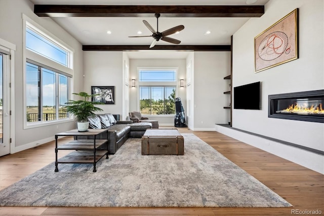 living room with beamed ceiling, ceiling fan, and light hardwood / wood-style flooring