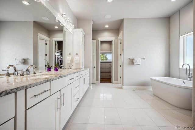 bathroom featuring a bathtub, vanity, and tile patterned floors