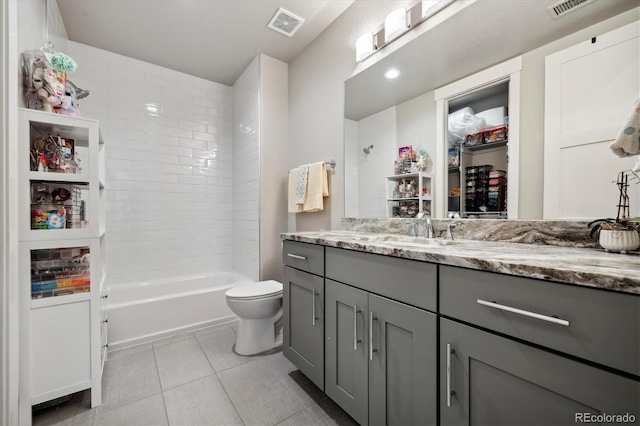 full bathroom featuring tiled shower / bath, vanity, toilet, and tile patterned floors