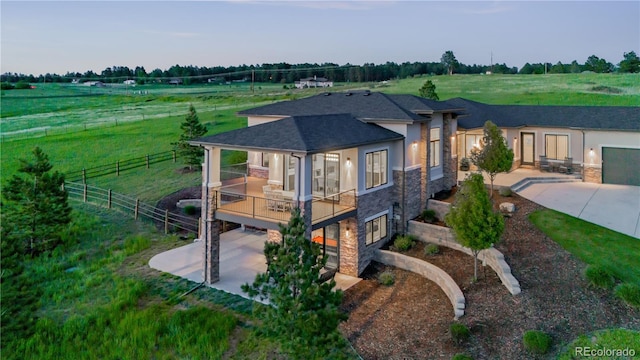 view of front of property with a garage, a rural view, and a patio area