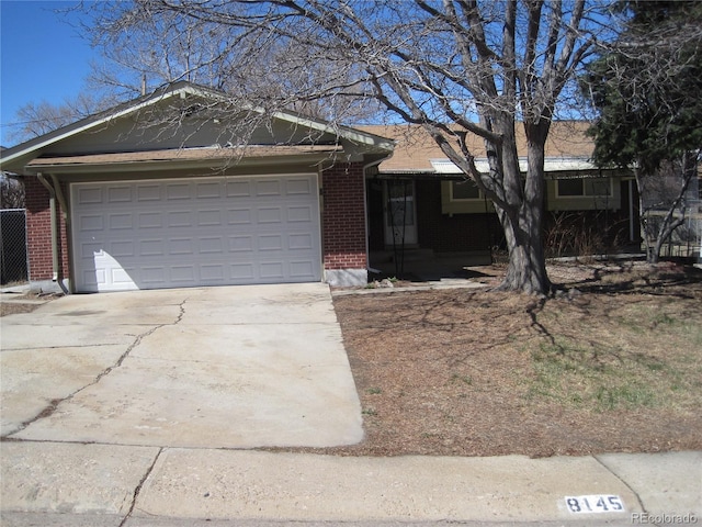 single story home featuring brick siding, concrete driveway, and an attached garage