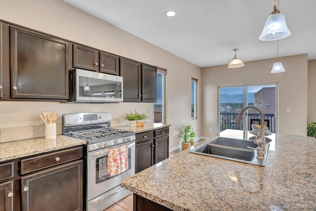 861 Circle Rd, Palmer Lake, CO 80133 - kitchen with dark brown cabinets, appliances with stainless steel finishes, a sink, and light wood finished floors
