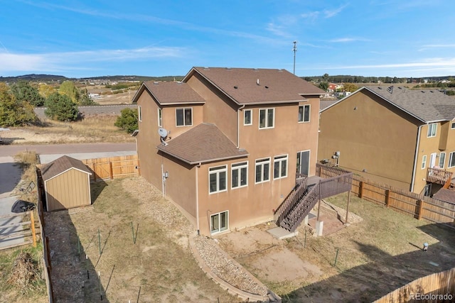 861 Circle Rd, Palmer Lake, CO 80133 - rear view of house with a storage shed, a deck, an outbuilding, a fenced backyard, and stucco siding