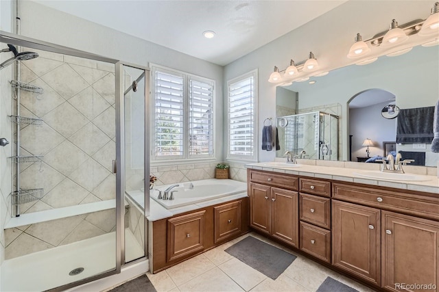 bathroom with tile floors, dual bowl vanity, and separate shower and tub