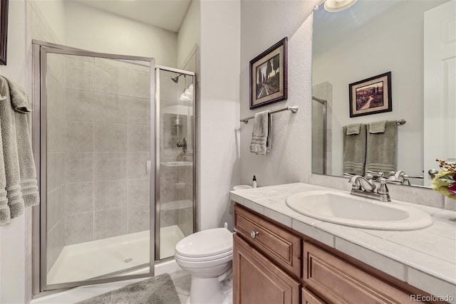 bathroom with a shower with door, toilet, and large vanity