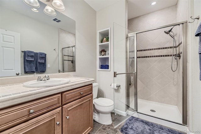 bathroom with a shower with door, toilet, tile floors, and vanity with extensive cabinet space