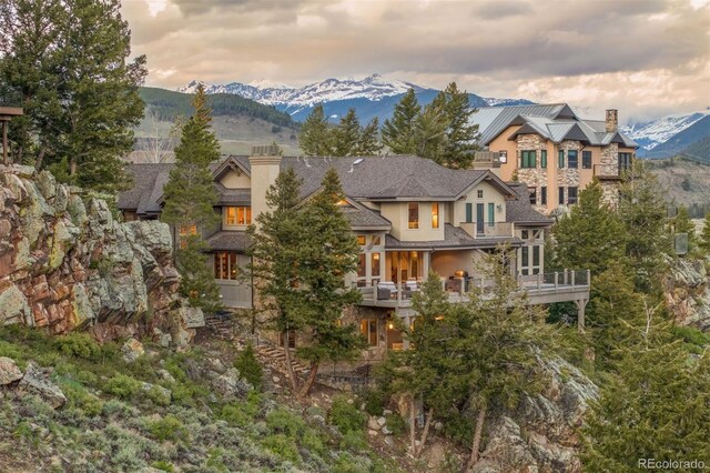 309 Eastridge Dr, Dillon, CO 80435 - rear view of house with a chimney, a balcony, a mountain view, and stucco siding