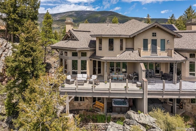 309 Eastridge Dr, Dillon, CO 80435 - rear view of house with a chimney, a balcony, stucco siding, outdoor dining space, and a mountain view