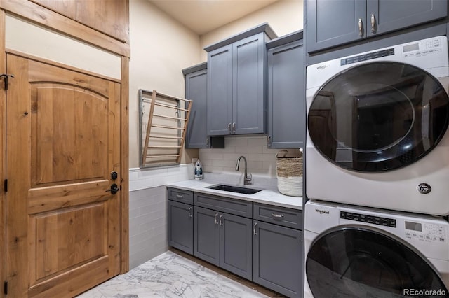 309 Eastridge Dr, Dillon, CO 80435 - laundry room with stacked washing machine and dryer, cabinet space, and light marble finish floors