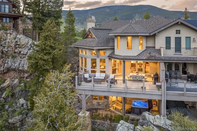 309 Eastridge Dr, Dillon, CO 80435 - back of house featuring roof with shingles, a mountain view, a chimney, a balcony, and stucco siding