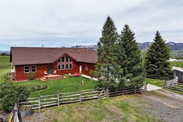 log home featuring a deck and a front lawn