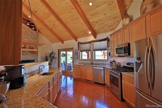 kitchen with beamed ceiling, light stone counters, sink, hardwood / wood-style flooring, and appliances with stainless steel finishes