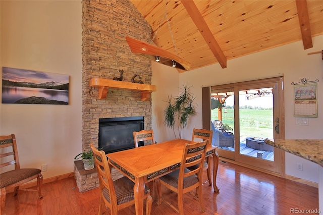 dining area with a fireplace, beam ceiling, wood ceiling, high vaulted ceiling, and wood-type flooring