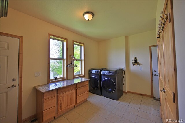 laundry area featuring light tile floors and washing machine and dryer