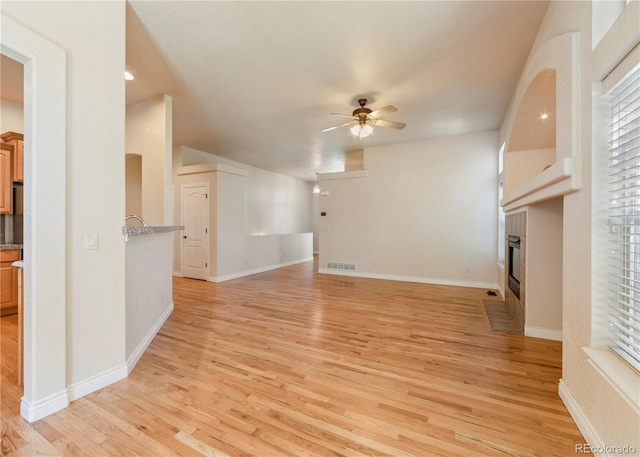 unfurnished living room with light hardwood / wood-style floors and ceiling fan