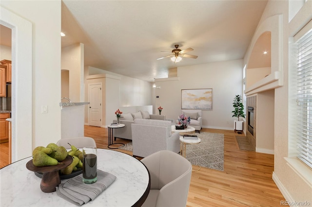 living room with ceiling fan and light hardwood / wood-style flooring