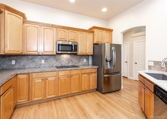 kitchen featuring backsplash, light hardwood / wood-style floors, appliances with stainless steel finishes, and sink