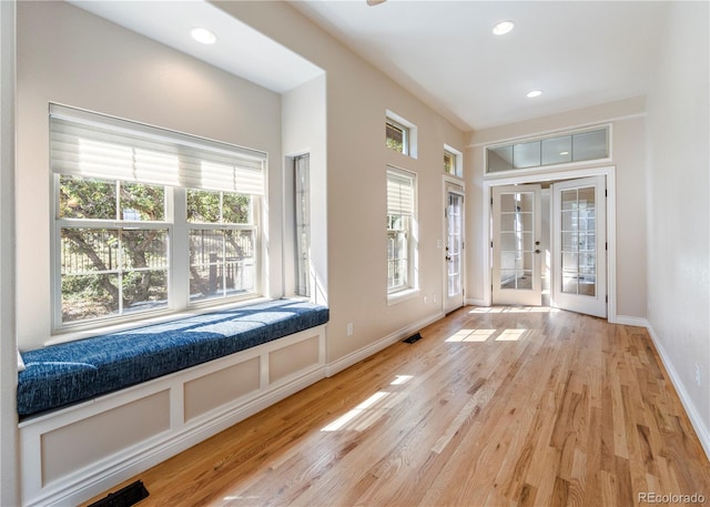 foyer with light hardwood / wood-style floors, french doors, and a wealth of natural light