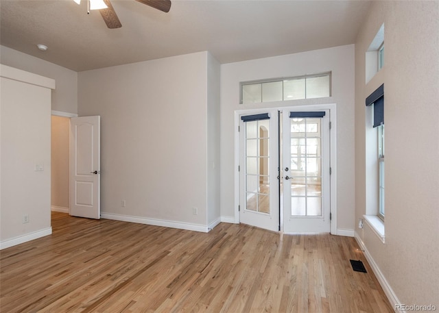 interior space featuring light wood-type flooring, ceiling fan, and french doors