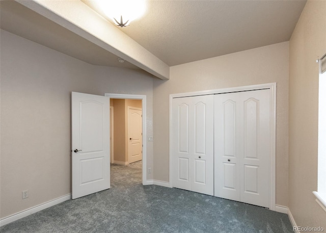 unfurnished bedroom with dark carpet and a closet