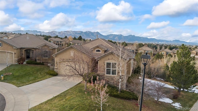 view of front of home with a mountain view, a garage, and a front yard