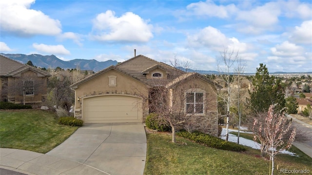 view of front of home featuring a mountain view, a garage, and a front lawn