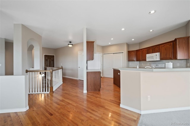 kitchen with a kitchen island, light wood-type flooring, and tasteful backsplash