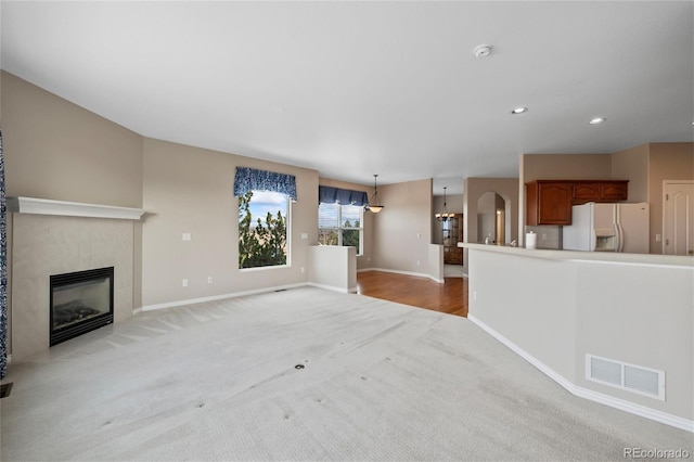 unfurnished living room featuring light carpet and a fireplace