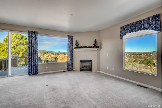 unfurnished living room with a tile fireplace and carpet floors