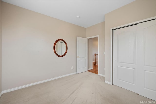 unfurnished bedroom with light carpet and a closet