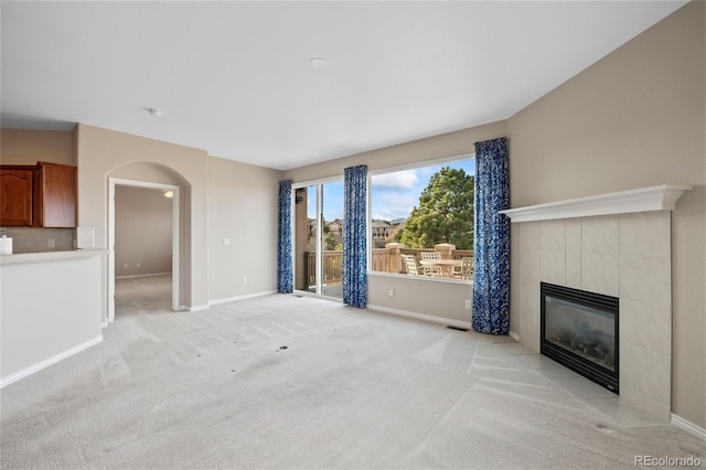 unfurnished living room with light colored carpet and a fireplace