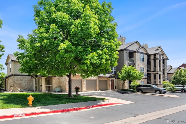 7422 S Quail Cir Unit 1624, Littleton, CO 80127 - view of front of house featuring driveway, a front yard, and a garage