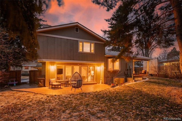 back house at dusk with a patio area and a fire pit