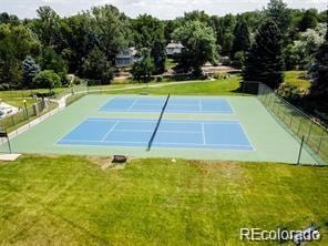 view of tennis court featuring a yard