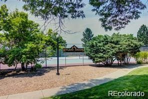 view of home's community featuring tennis court