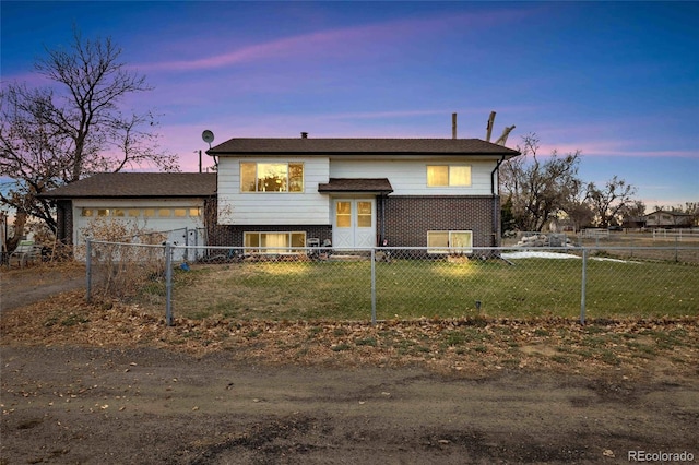 bi-level home featuring a garage and a yard