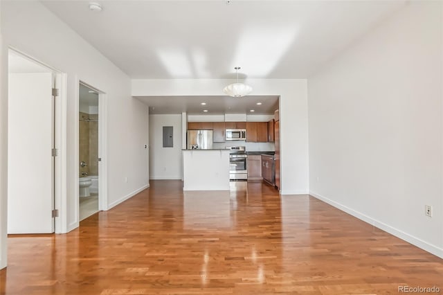 unfurnished living room with electric panel and light hardwood / wood-style flooring