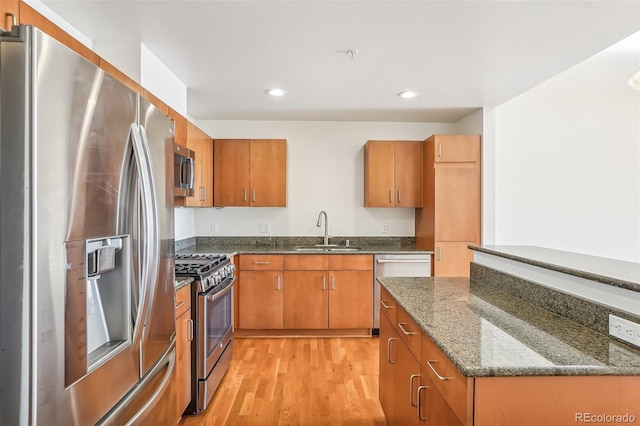 3601 Arapahoe Ave Unit 226, Boulder, CO 80303 - kitchen with appliances with stainless steel finishes, a sink, brown cabinetry, light wood-type flooring, and recessed lighting