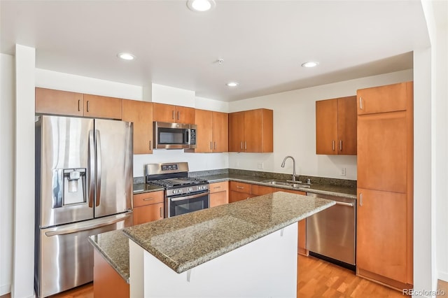 3601 Arapahoe Ave Unit 226, Boulder, CO 80303 - kitchen with stainless steel appliances, a sink, dark stone countertops, brown cabinetry, and a kitchen island