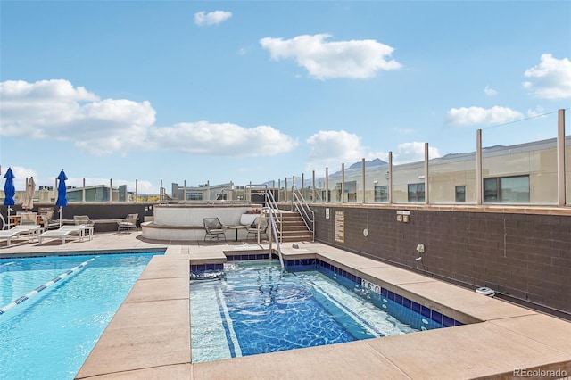 view of pool with a jacuzzi and a patio