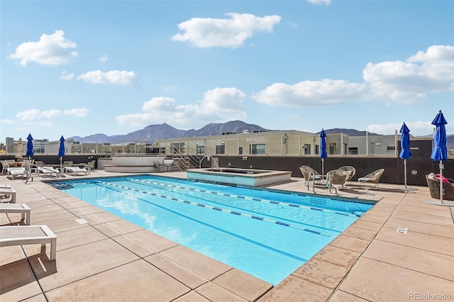 view of pool with a mountain view, a patio area, and a community hot tub