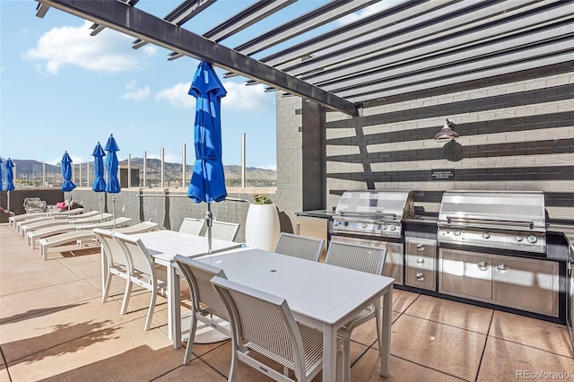 3601 Arapahoe Ave Unit 226, Boulder, CO 80303 - view of patio / terrace with outdoor dining space, area for grilling, a pergola, and exterior kitchen