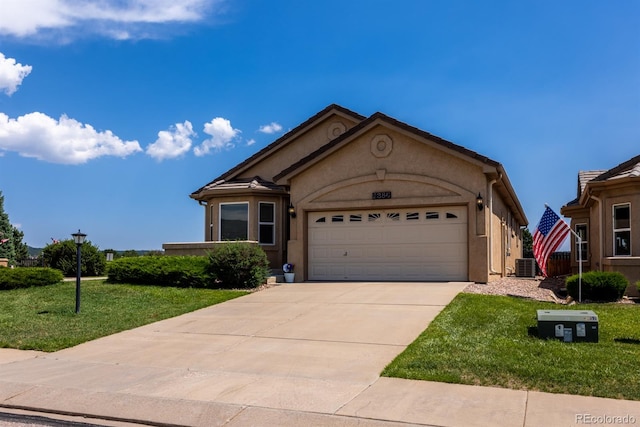 view of front of property featuring cooling unit, a garage, and a front yard