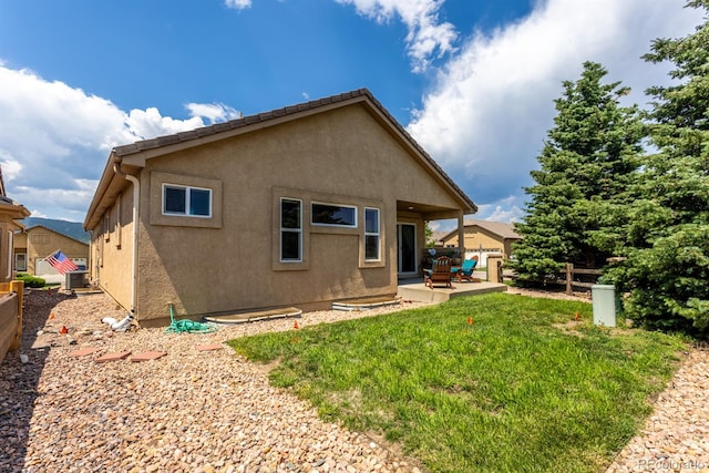 back of property featuring a patio, cooling unit, and a lawn