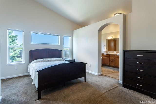 tiled bedroom with ensuite bathroom and high vaulted ceiling