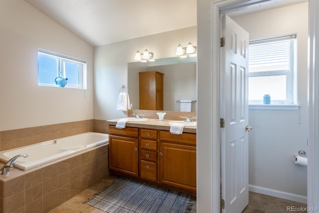 bathroom featuring tiled bath, dual vanity, tile patterned floors, and plenty of natural light