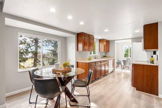 dining room with light wood-style flooring, recessed lighting, and baseboards