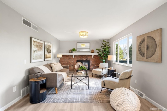living area with wood finished floors, baseboards, and a fireplace