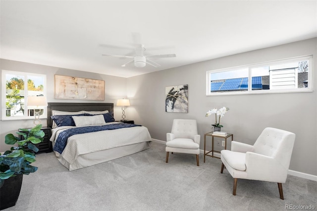 carpeted bedroom with multiple windows, baseboards, and a ceiling fan